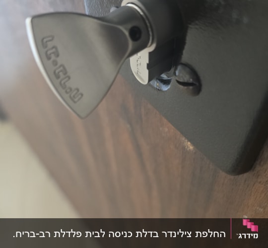 מפתח מתכת בתוך מנעול על דלת עץ